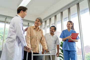 Obraz premium Senior female patient walk with walker physical therapist and doctor teaching