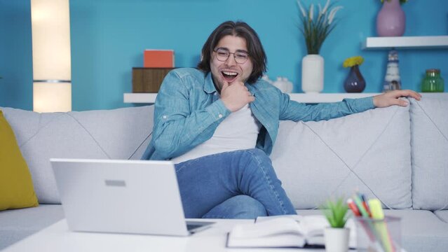 Cheerful young man watching video with funny content.