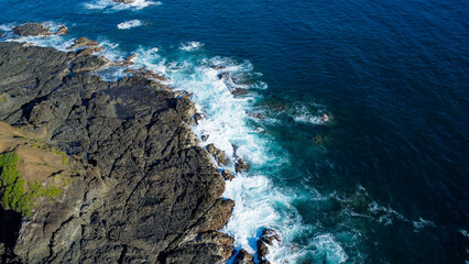 Top view of rock coastline natural breakwater with foam formed by the constant waves of the Pacific Ocean taken at Pedasí, Panama.