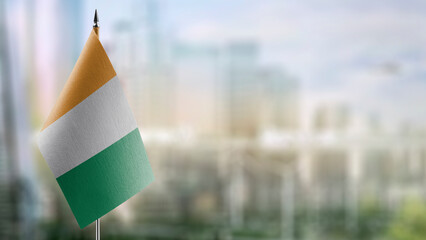 Small flags of the Cote dIvoire on an abstract blurry background
