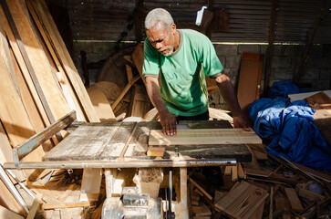 A man Using An Electric Saw To Cut Boards