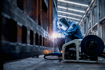 Industrial welder welding fabricated construction in factory, Welding process by Flux Core Welding, FCAW