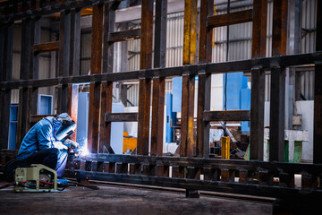 Industrial welder welding fabricated construction in factory, Welding process by Flux Core Welding, FCAW - obrazy, fototapety, plakaty