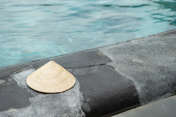 Vietnamese traditional hat 'Non La' at the resort swimming pool