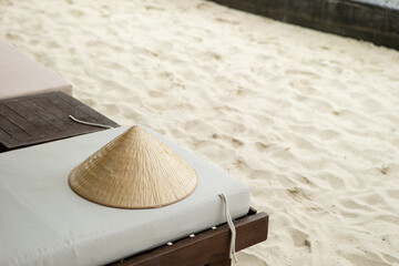 Vietnamese traditional hat 'Non La' on a beach chair by the beach
