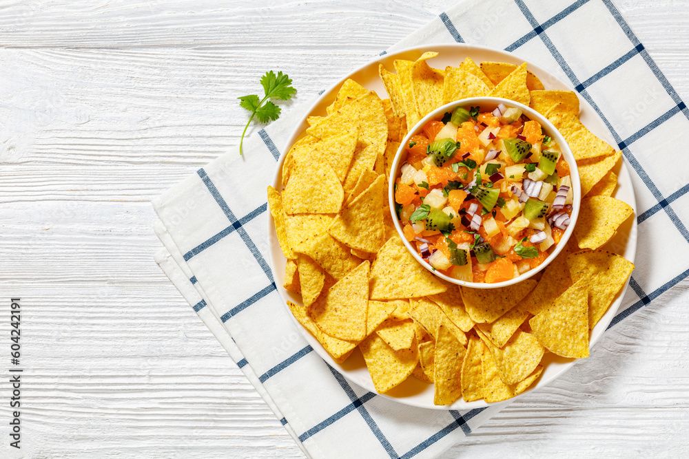 Sticker summer fruit salsa with tortilla chips on plate