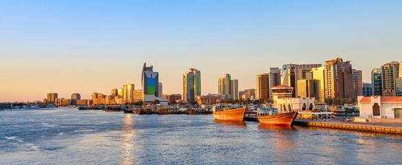 Naklejka premium Dubai Creek bay with skyscrapers, traditional boats and piers in UAE