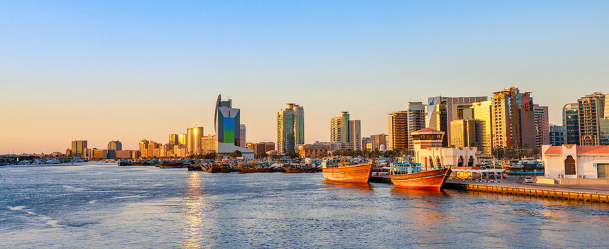 Dubai Creek bay with skyscrapers, traditional boats and piers in UAE