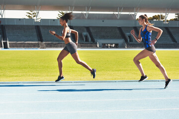 Fototapeta premium Woman, running and stadium track of athletes in competition, fitness or athletics in the outdoors. Fit, active or sporty women, runner or sprinting in exercise, workout or training for healthy cardio