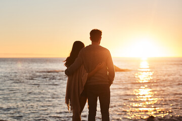 Sunset, beach and back of couple hug in evening on holiday, summer vacation and weekend by ocean. Nature, love and man and woman embrace, hugging and relax for bonding, quality time and peace by sea