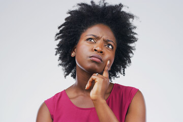 Fototapeta na wymiar Confused, thinking and black woman in studio with frown, decision or choice on grey background space. Doubt, suspicious and African female person concerned, unsure or pensive and contemplating