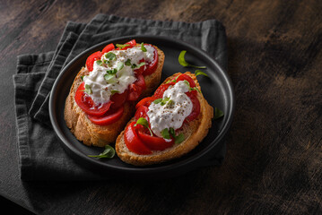 two bruschetta with tomatoes on a wooden background