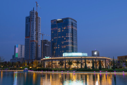 TASHKENT, UZBEKISTAN - SEPTEMBER 16, 2022: Multi-storey building of the Hilton hotel in the cityscape on a evening twilight
