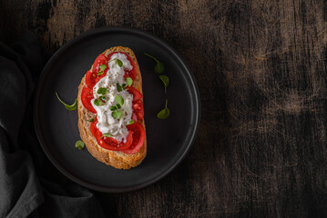 bruschetta with tomatoes on a black plate