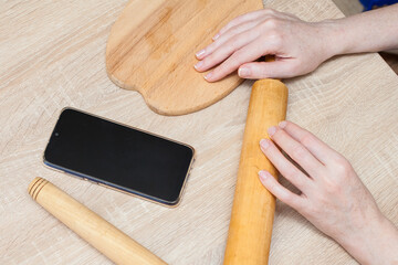 The girl is looking on the phone for a recipe for making bread products from flour. A live shot of a woman's everyday life at home.