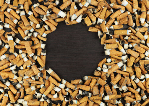 Many smoked cigarettes. Environmental pollution. Smoking harms health. Problems and depression. A person smokes a lot. Background from cigarettes. A brown filter in a cigarette. NO SMOKING