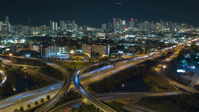 Aerial view of american highway junction at night with fast driving vehicles in Miami, Florida. Time lapse of USA transportation infrastructure