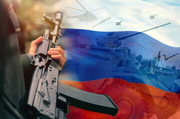 A rifle in the hands of a Russian soldier against the background of the flag of the Russian Federation and the silhouettes of military armored vehicles and aviation. The concept of mobilization.