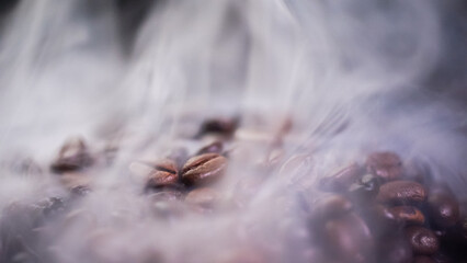 Coffee beans roasting with smoke, selective focus, and soft focus.