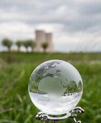 glass earth globe against nuclear power plant