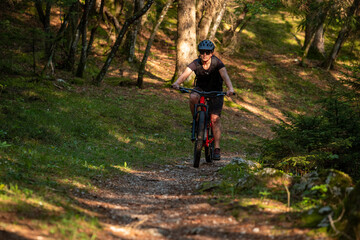 Female cyclist on her mountain bike riding through the hills on a sunny day.