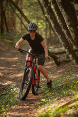 Fototapeta na wymiar Female cyclist on her mountain bike riding through the hills on a sunny day.