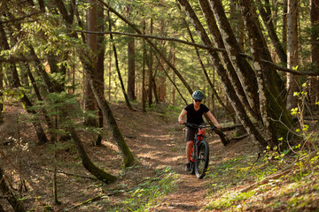 Fototapeta na wymiar Female cyclist on her mountain bike riding through the hills on a sunny day.