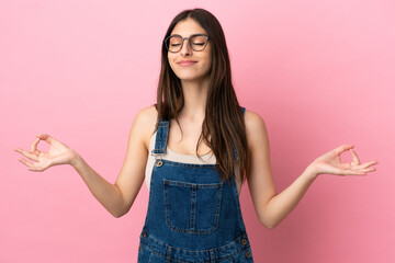 Young caucasian woman isolated on pink background in zen pose