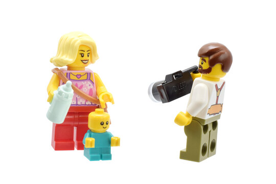Editorial illustrative image of lego minifigures of father, mother and baby. Happy smiling family take a picture isolated on white.