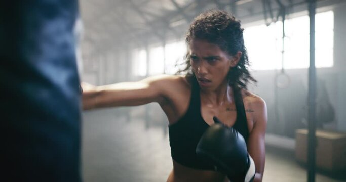 Boxing, sweating and punching bag with woman in gym for martial arts, workout and strong. Focus, health and cardio with female boxer in mma fitness center for training, exercise and performance