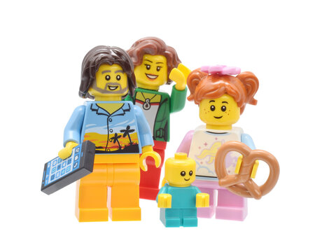 Editorial illustrative image of lego minifigures of father, mother, daughter and son baby. Happy smiling family isolated on white.