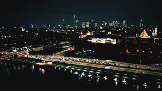Night time lapse of Warsaw's Old Town viewed from the royal castle at a height. Beautiful architecture and city lights in Poland. Modern downtown financial center view after sunset, dusk cityscape, 