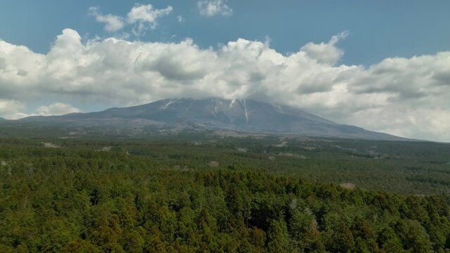 雲がかかる富士山とその麓の青木ヶ原樹海　空撮