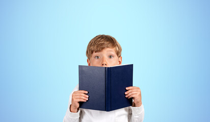 Astonished schoolboy with book, blue
