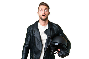 Young caucasian man with a motorcycle helmet over isolated chroma key background looking up and...