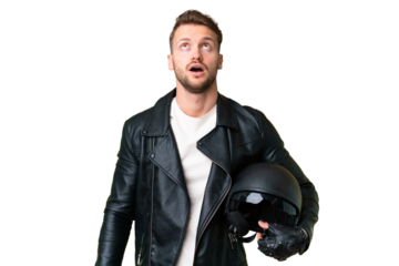 Young caucasian man with a motorcycle helmet over isolated chroma key background looking up and with surprised expression