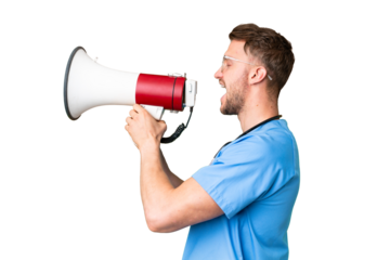 Young nurse man over isolated chroma key background shouting through a megaphone