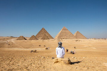 Person in the desert of Giza Pyramids - obrazy, fototapety, plakaty
