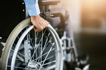 Wheelchair, care and man hand holding wheel in a hospital for healthcare. Person with disability, mobility and male adult in clinic for support and medical help with hands of patient and mockup