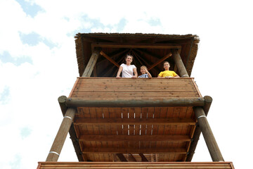 Mother with two sons on observation wooden tower