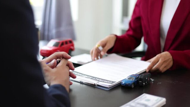 The customer signs a car purchase contract with the sales agent. Finance and auto loans, lease agreement.