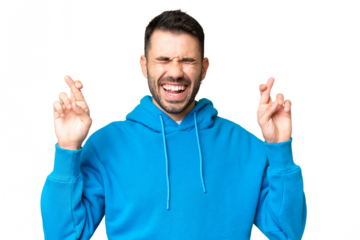 Young handsome caucasian man over isolated chroma key background with fingers crossing