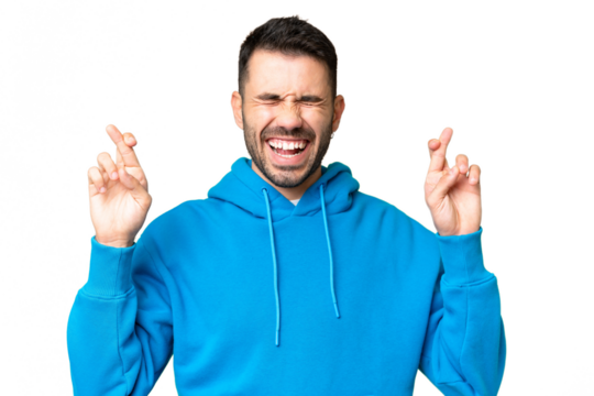 Young handsome caucasian man over isolated chroma key background with fingers crossing