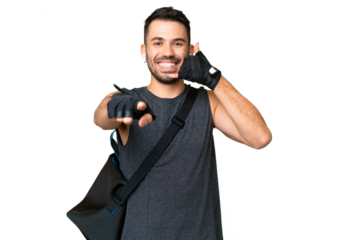 Young sport caucasian man with sport bag over over isolated chroma key background making phone gesture and pointing front