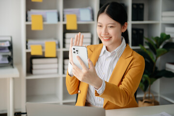  Working woman concept a female manager attending video conference and holding tablet, smatrphone in office.