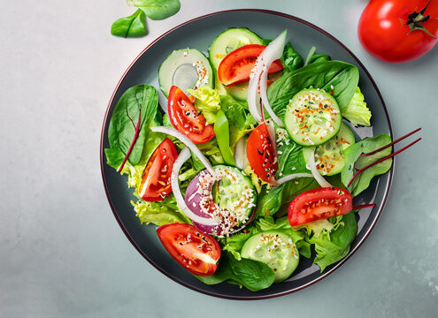Fresh vegetable salad with tomato, cucumber, lettuce, onion and sesame seeds. Generated AI