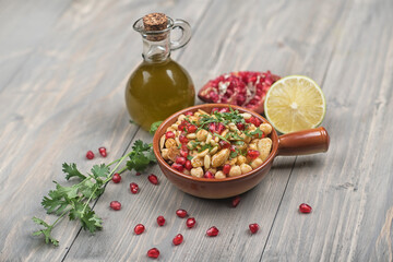 chickpeas salad seasoned with lemon and topped with pomegranate, almonds, and parsley
