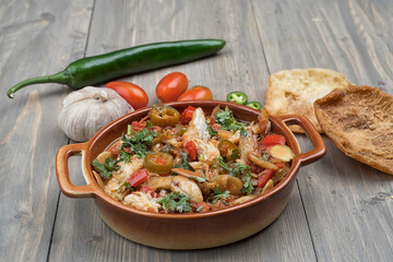 arabian food of Chicken in tomato paste with spicy pickles, tomatoes and almonds 