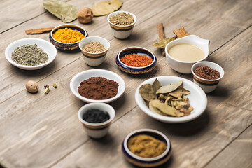 large collection of different spices and herbs on a wooden table 