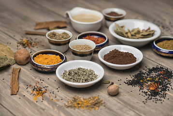 large collection of different spices and herbs on a wooden table 